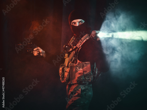 Special forces soldier with a pistol and a flashlight