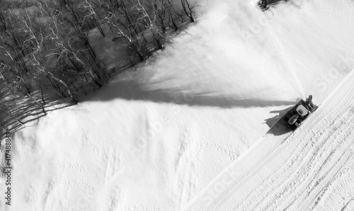 Snow thrower is cleaning the snow. Bird’s eye view. Black and white. photo