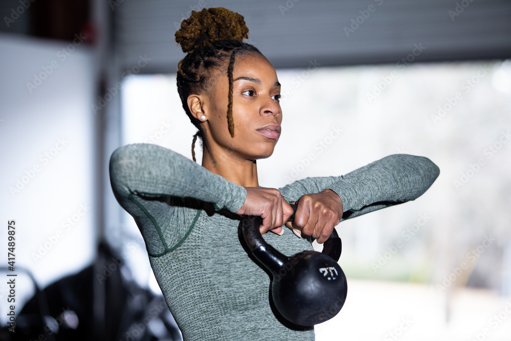 Black woman does fitness workout, kettlebell upright row Stock Photo ...