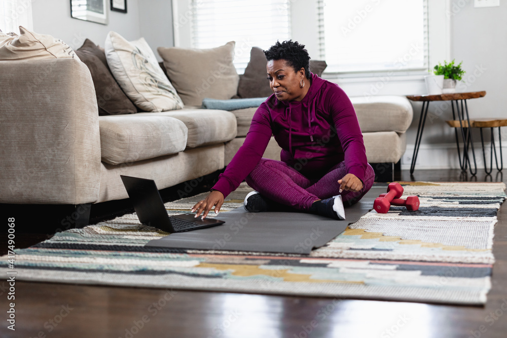 Black woman exercises while watching online tutorial fitness class Black woman exercises while watching online tutorial fitness class