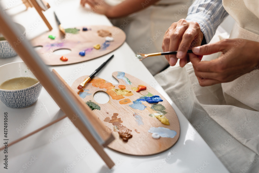 DIverse mother and son painting at home, kid activities DIverse mother and son painting at home, kid activities