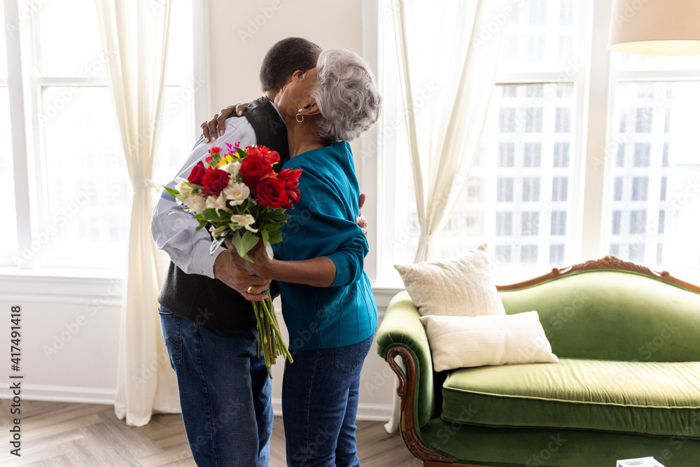 Senior couple celebrating wedding anniversary with roses at home, love connection Senior couple celebrating wedding anniversary with roses at home, love connection