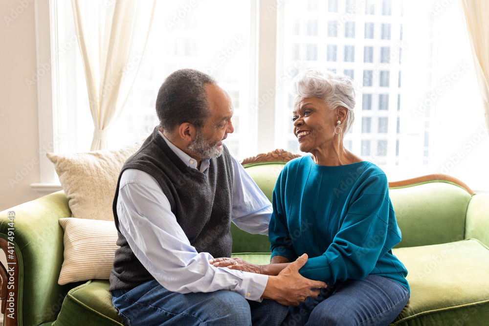 Senior Black couple in love, sitting on couch at home Senior Black couple in love, sitting on couch at home