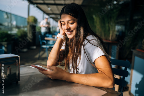 Young woman in a cafe holding a smartphone in her hands