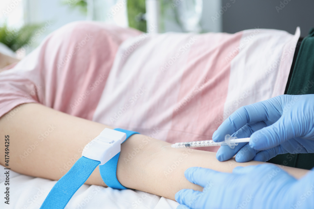 Doctor gives an intravenous injection to a patient in hospital Doctor gives an intravenous injection to a patient in hospital