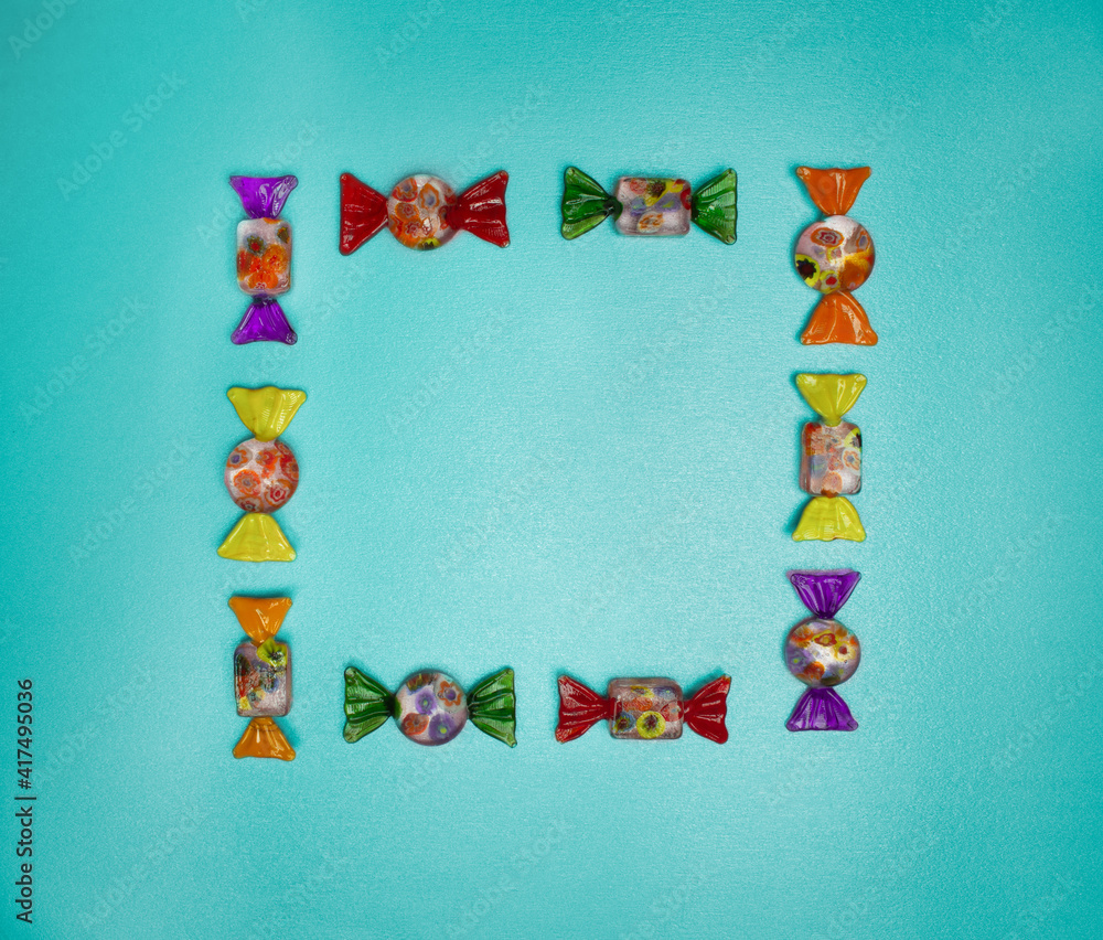 Fototapeta premium Candy frame on green background, top view. 