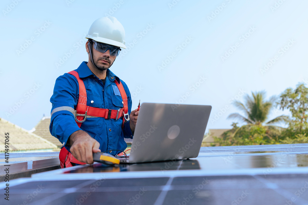 An Engineer use a laptop computer to examine the solar cell panel An Engineer use a laptop computer to examine the solar cell panel