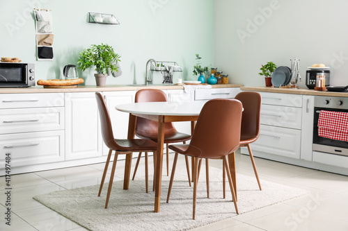 Stylish interior of modern kitchen with dining table © Pixel-Shot