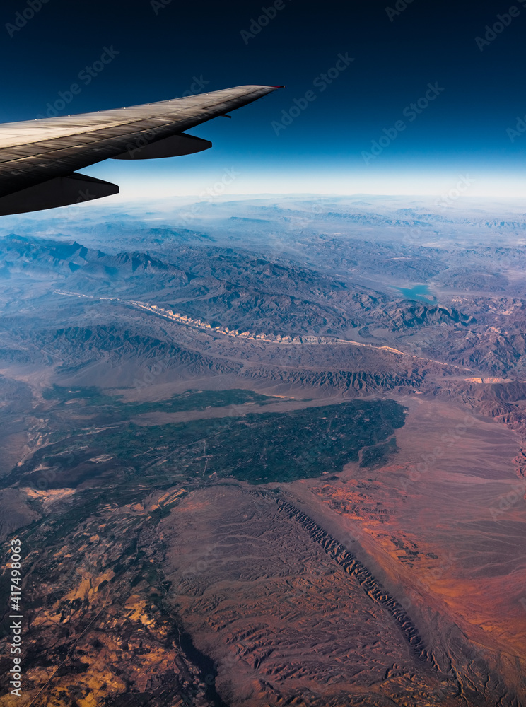 Aerial View from an Airplane. Flying above Beautiful Land at Sunrise.