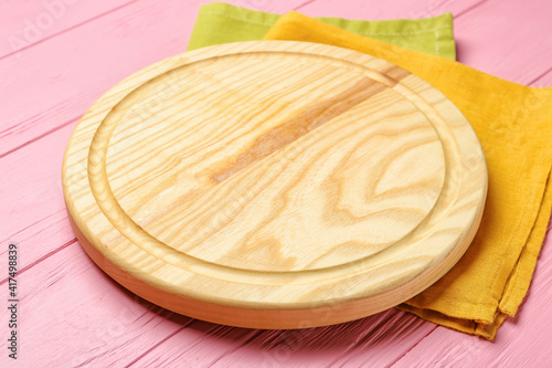 Cutting board on color wooden background