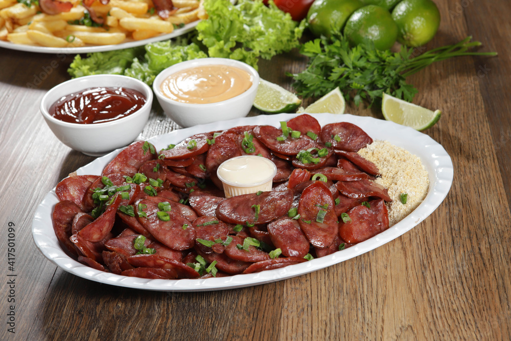 Portion of pepperoni sausage with lemon. Lettuce, green onion, ketchup and mayonnaise Portion of pepperoni sausage with lemon. Lettuce, green onion, ketchup and mayonnaise