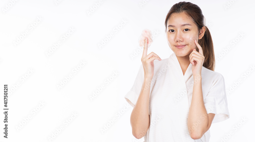 Cosmetology, hygiene, removal, spa, freshness skin care concept. Beauty Asian young woman wear bathrobe holding cotton pad in hands after using cleanser remove makeup own face over white background. Cosmetology, hygiene, removal, spa, freshness skin care concept. Beauty Asian young woman wear bathrobe holding cotton pad in hands after using cleanser remove makeup own face over white background.
