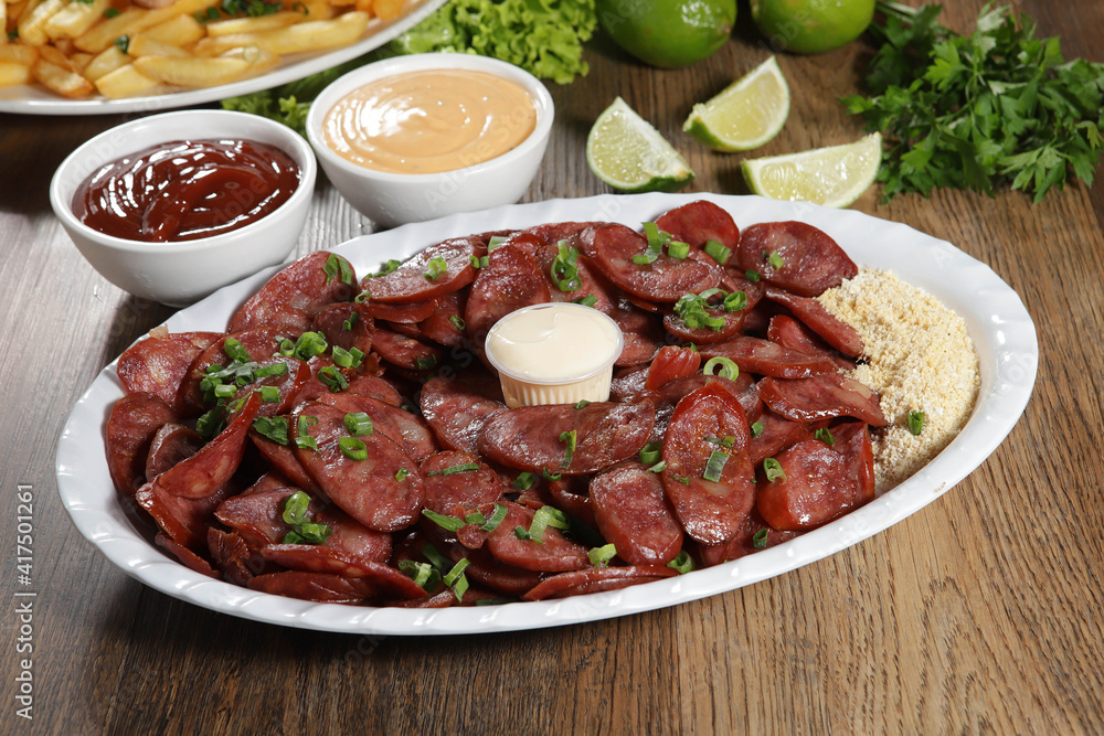 Portion of pepperoni sausage with lemon. Lettuce, green onion, ketchup and mayonnaise Portion of pepperoni sausage with lemon. Lettuce, green onion, ketchup and mayonnaise