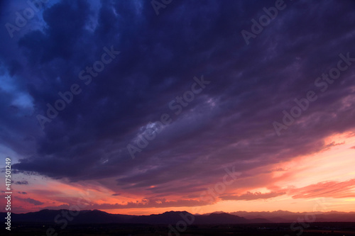 dramatic sunset over long's peak and the front range of the colorado rocky mountains as seen from broomfield, colorado