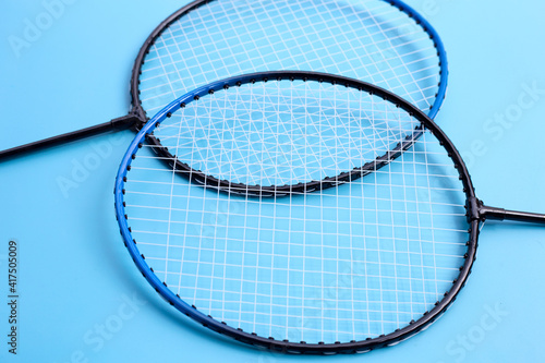 Badminton rackets on blue background. © Bowonpat
