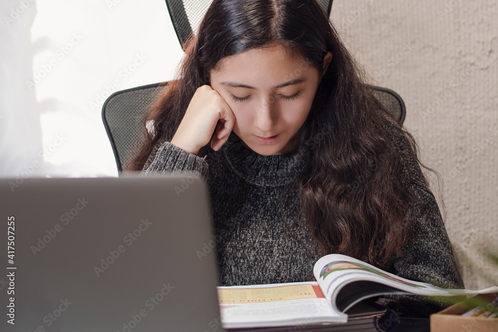 Hispanic Latino teen girl woman takes distance classes online with her teacher sheltering at home from the covid-19 pandemic Hispanic Latino teen girl woman takes distance classes online with her teacher sheltering at home from the covid-19 pandemic