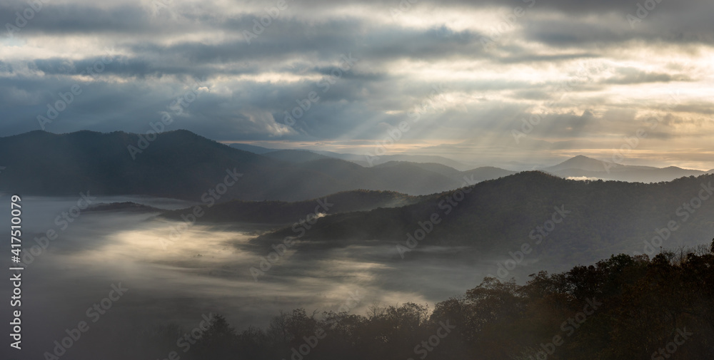 Dramatic autumn weather - with clouds, fog and morning sun rays - in the Blue Ridge Parkway Mountains, Pounding Mill Overlook Dramatic autumn weather - with clouds, fog and morning sun rays - in the Blue Ridge Parkway Mountains, Pounding Mill Overlook