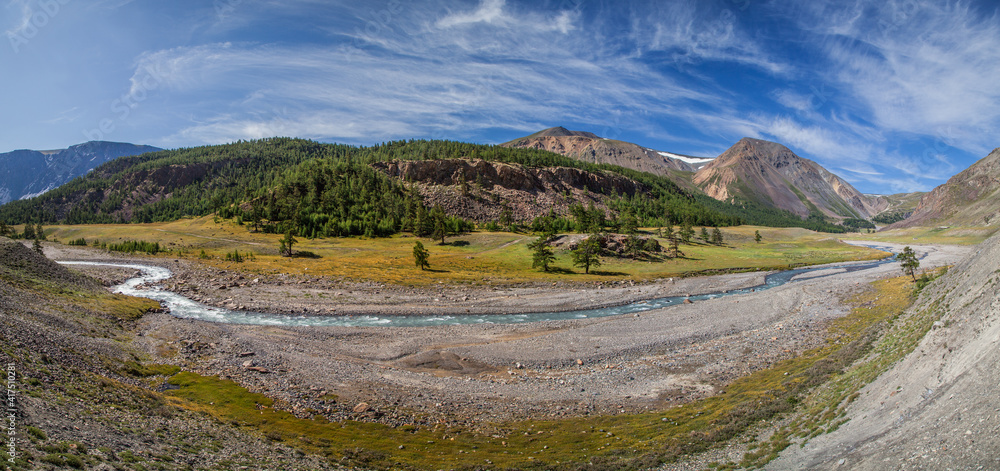 Mountain valley with river, dry slopes and forest. Panoramic view.