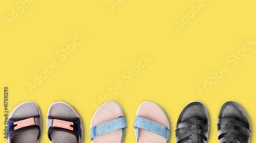 Row colorful female summer shoes collection yellow background close up top view, women fashion sandals set, comfortable flip-flop, stylish flat sole walking footwear, shoe shop, store sale, copy space