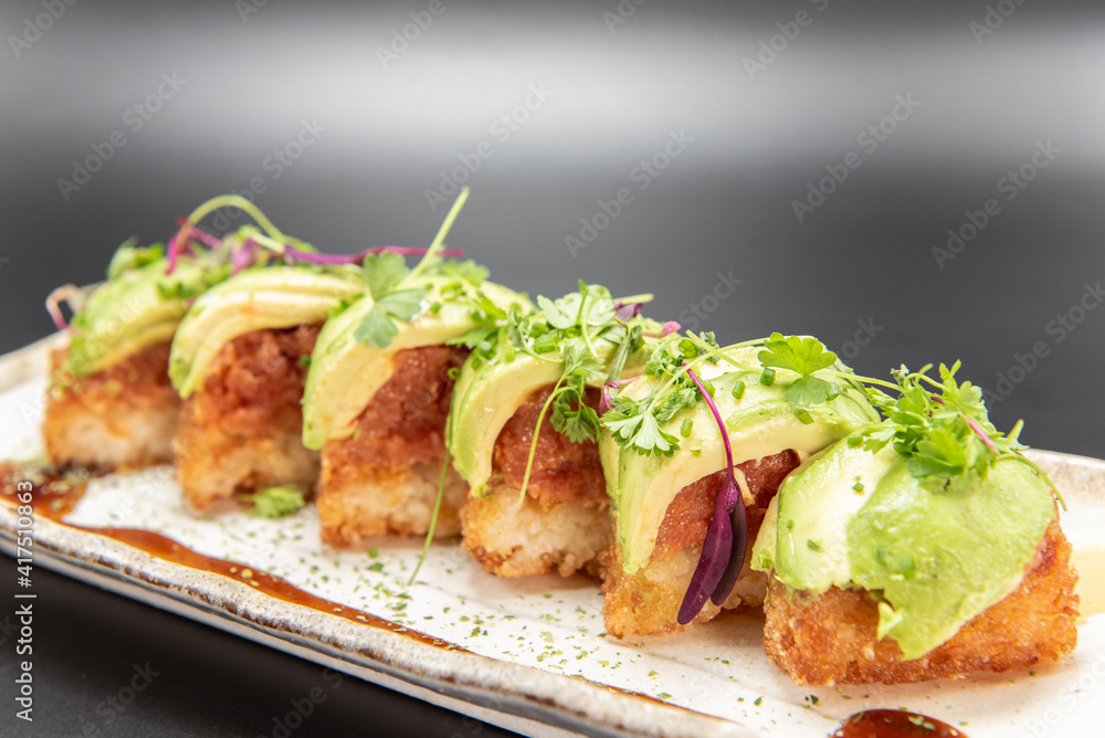 Crispy rice pieces topped with spicy tuna and avocado drizzled with spicy mayo and unagi sauce. Crispy rice pieces topped with spicy tuna and avocado drizzled with spicy mayo and unagi sauce.