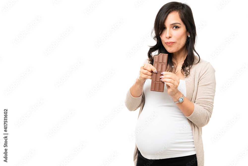 Hungry pregnant woman taking a bite off a chocolate Hungry pregnant woman taking a bite off a chocolate