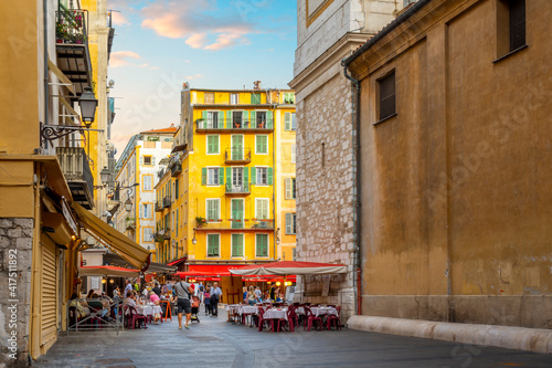 Fototapeta Naklejka Na Ścianę i Meble -  A lively afternoon at the Place Rossetti as tourists enjoy the cafes and shops in the colorful Vieux Old Town of Nice, France on the French Riviera.