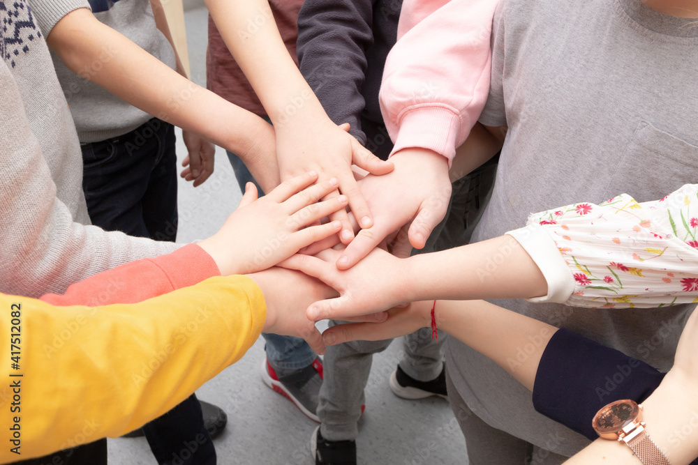 many different children's hands and the teacher's hand are held together while playing at school during recess many different children's hands and the teacher's hand are held together while playing at school during recess