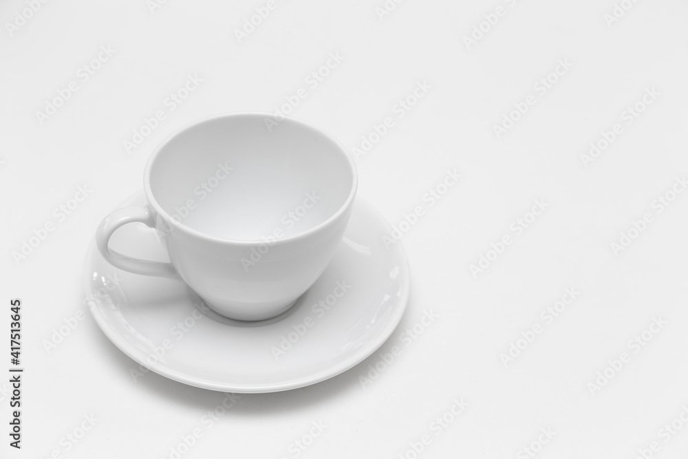 A white ceramic coffee mug is placed on a white table top. A white ceramic coffee mug is placed on a white table top.