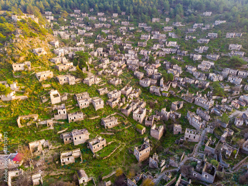 View from drone of ancient ruined settlement of Kayakoy with deserted houses and churches on mountain slope in Mugla Province, Turkey photo