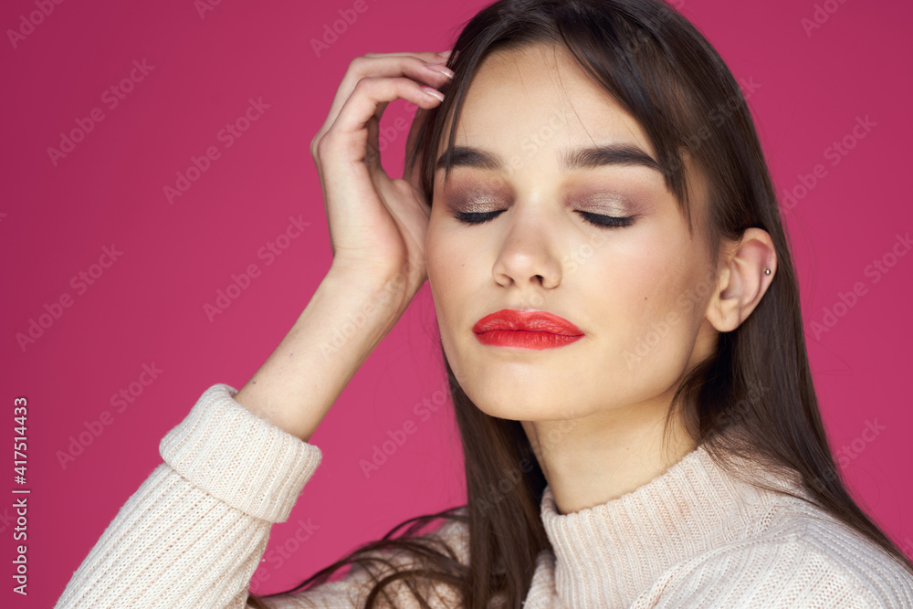 Brunette with long hair red lips cosmetics white sweater pink background cropped view Brunette with long hair red lips cosmetics white sweater pink background cropped view