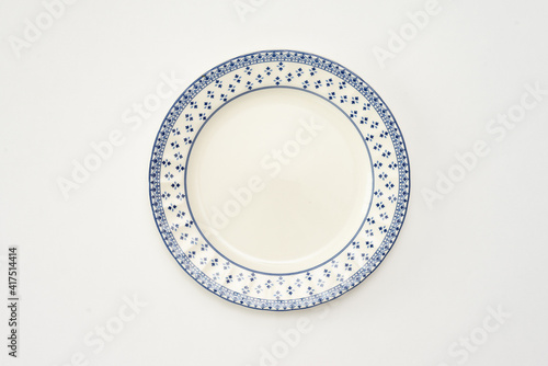hermoso plato blanco con figuras, estilo casa de la abuela, fondo blanco, foto clave alta, objetos de cocina del hogar, marco azul