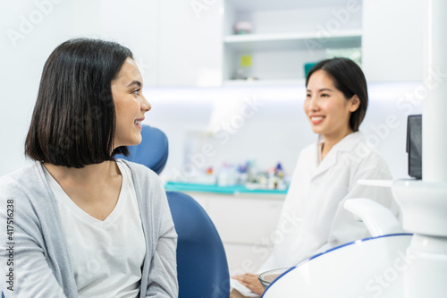 Caucasian girl consulting Asian female dentist about oral care checkup
