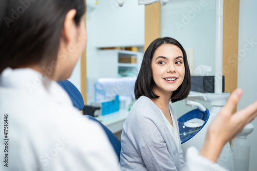 Asian dentist giving advice to patient girl about oral care treatment.
