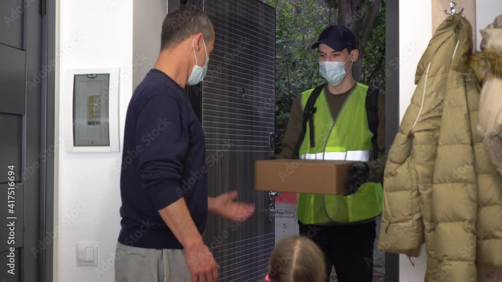 Help and support during COVID-19: Volunteer, Donate. A man courier in protective mask and medical gloves. Father and child pick up the parcel. Lockdown and social distancing during coronavirus Help and support during COVID-19: Volunteer, Donate. A man courier in protective mask and medical gloves. Father and child pick up the parcel. Lockdown and social distancing during coronavirus