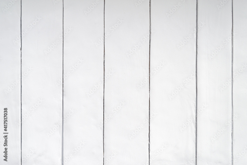 Vertical wooden planks close up. The wall is painted light gray. Vertical wooden planks close up. The wall is painted light gray.