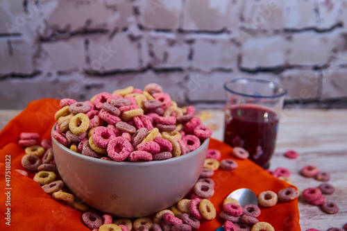 bad breakfast of colorful cereals full of sugar with red fruit juice