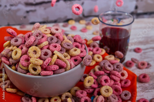 bad breakfast of colorful cereals full of sugar with red fruit juice