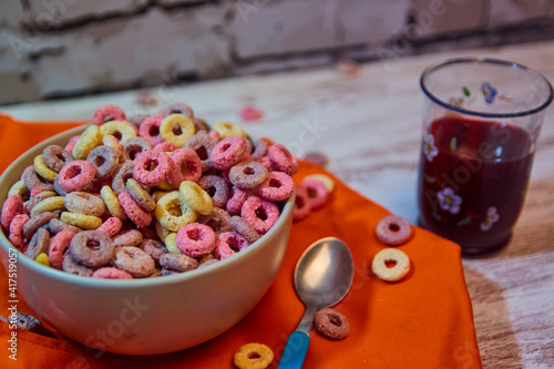 bad breakfast of colorful cereals full of sugar with red fruit juice