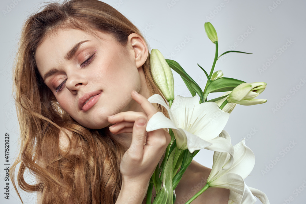 Emotional woman with flowers spring model naked shoulders clear skin