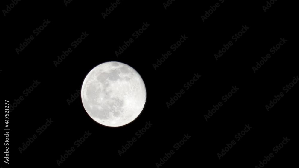 Fast-motion close-up view of Snow Moon filling 10% of the screen against a black background Fast-motion close-up view of Snow Moon filling 10% of the screen against a black background