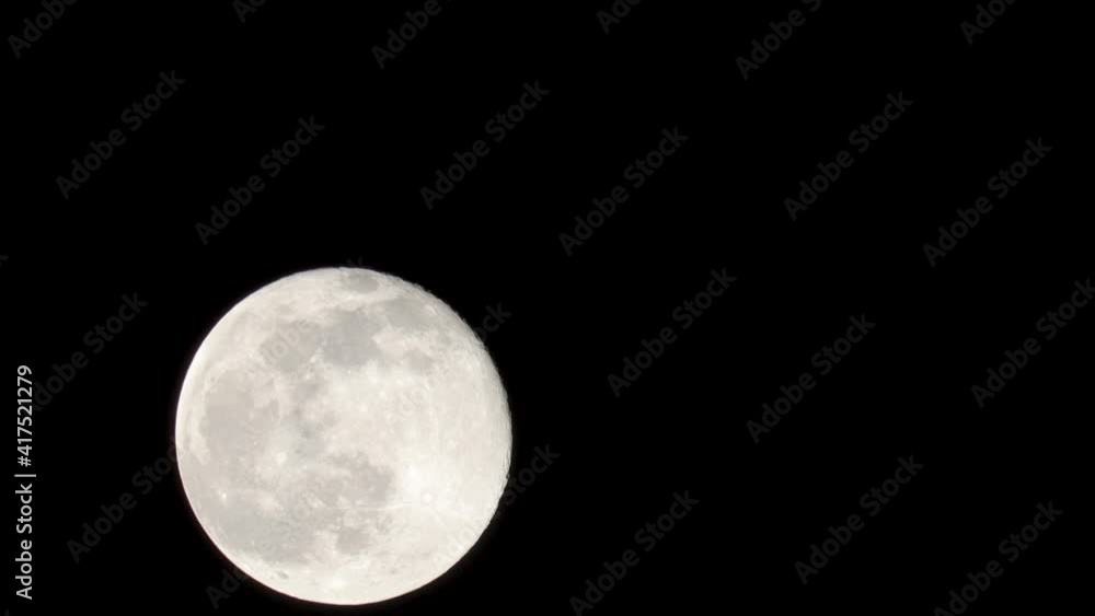 Fast-motion close-up view of Snow Moon filling 20% of the screen against a black background Fast-motion close-up view of Snow Moon filling 20% of the screen against a black background