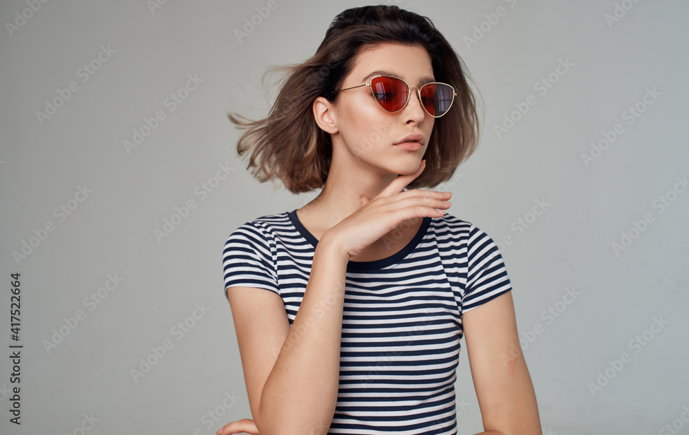Fototapeta premium romantic woman in striped t-shirt portrait on gray background and fashionable glasses on face
