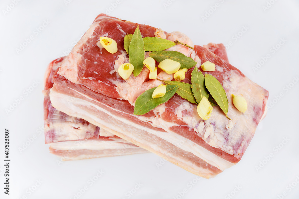 Boneless raw pork belly with garlic isolated on white background. Boneless raw pork belly with garlic isolated on white background.