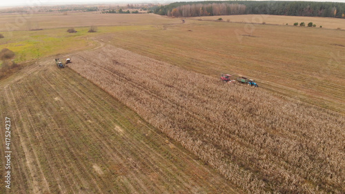Foto Two pairs of combined agricultural crews harvesting corn in the fall