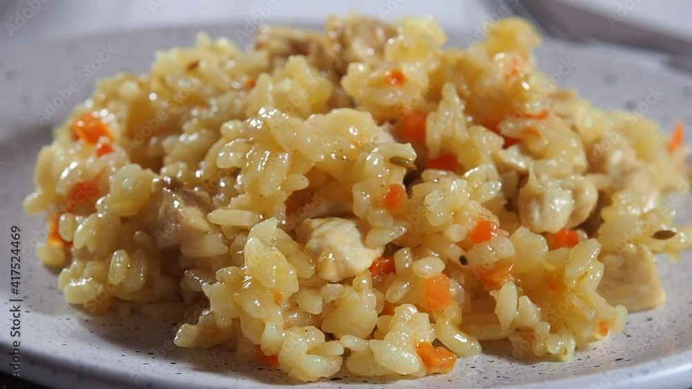 Hot delicious pilaf with rice and chicken decorate with a sprig of fresh parsley. Hot delicious pilaf with rice and chicken decorate with a sprig of fresh parsley.