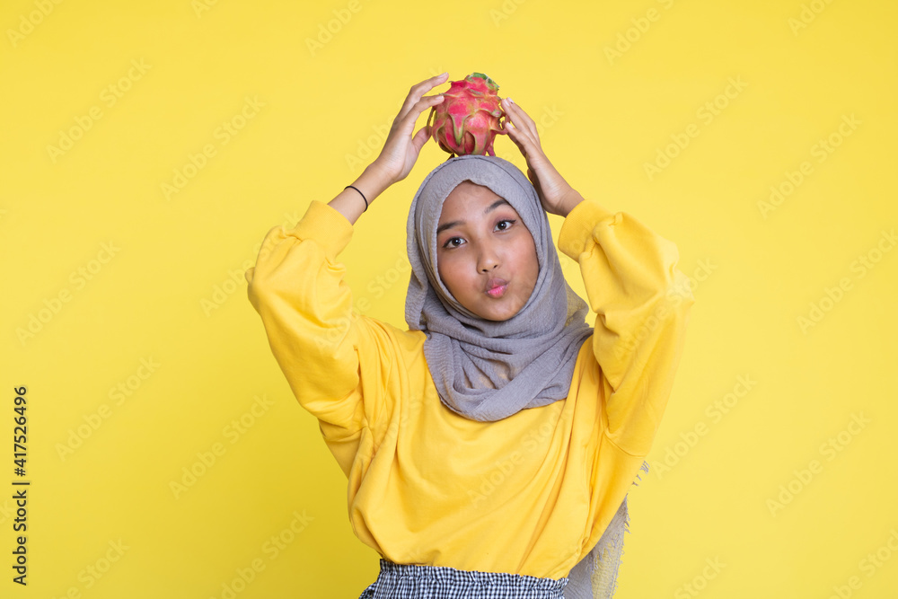 beautiful girl with dragon fruit on yellow background