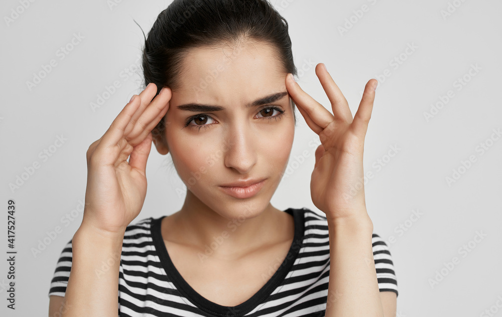 Fototapeta premium woman in t-shirt holding her head discontent health problem