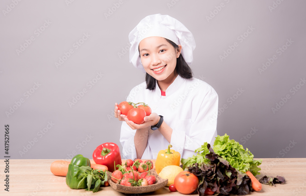 Portrait of a young Asian female chef ready to cook a new dish in the kitchen. Portrait of a young Asian female chef ready to cook a new dish in the kitchen.