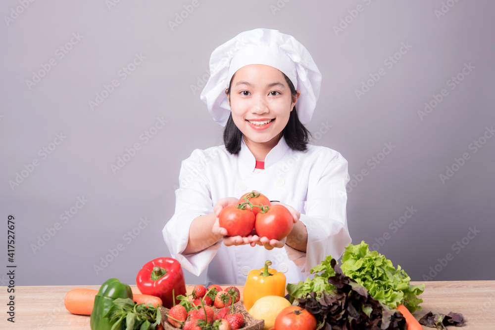 Portrait of a young Asian female chef ready to cook a new dish in the kitchen. Portrait of a young Asian female chef ready to cook a new dish in the kitchen.