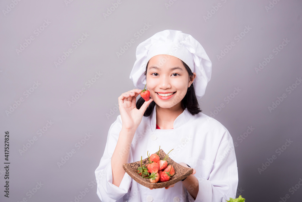 Portrait of a young Asian female chef ready to cook a new dish in the kitchen. Contains Strawberry as an ingredient Portrait of a young Asian female chef ready to cook a new dish in the kitchen. Contains Strawberry as an ingredient